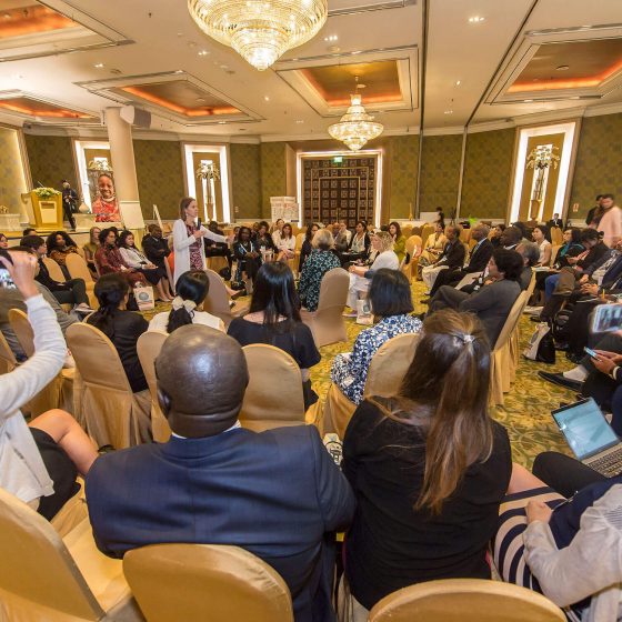 Women with microphone addressing a room of people
