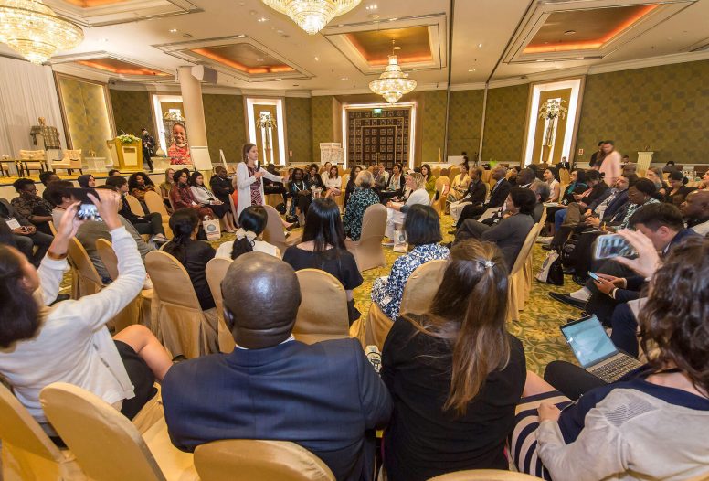 Women with microphone addressing a room of people