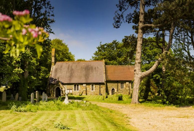 A church set among trees on a sunny day