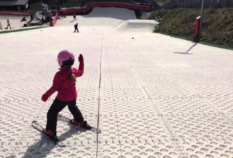 Little girl skiing down a dry ski slope