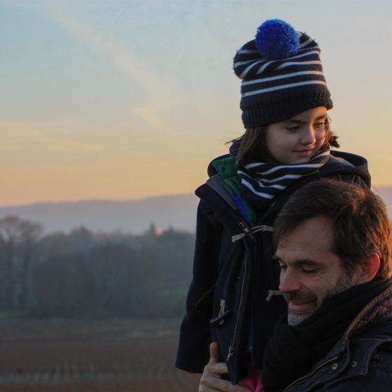 Man with child wearing winter clothes in the countryside