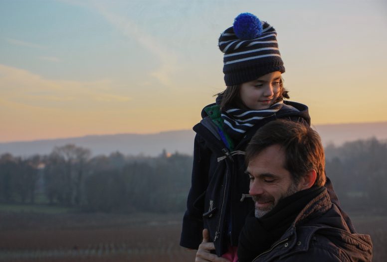 Man with child wearing winter clothes in the countryside