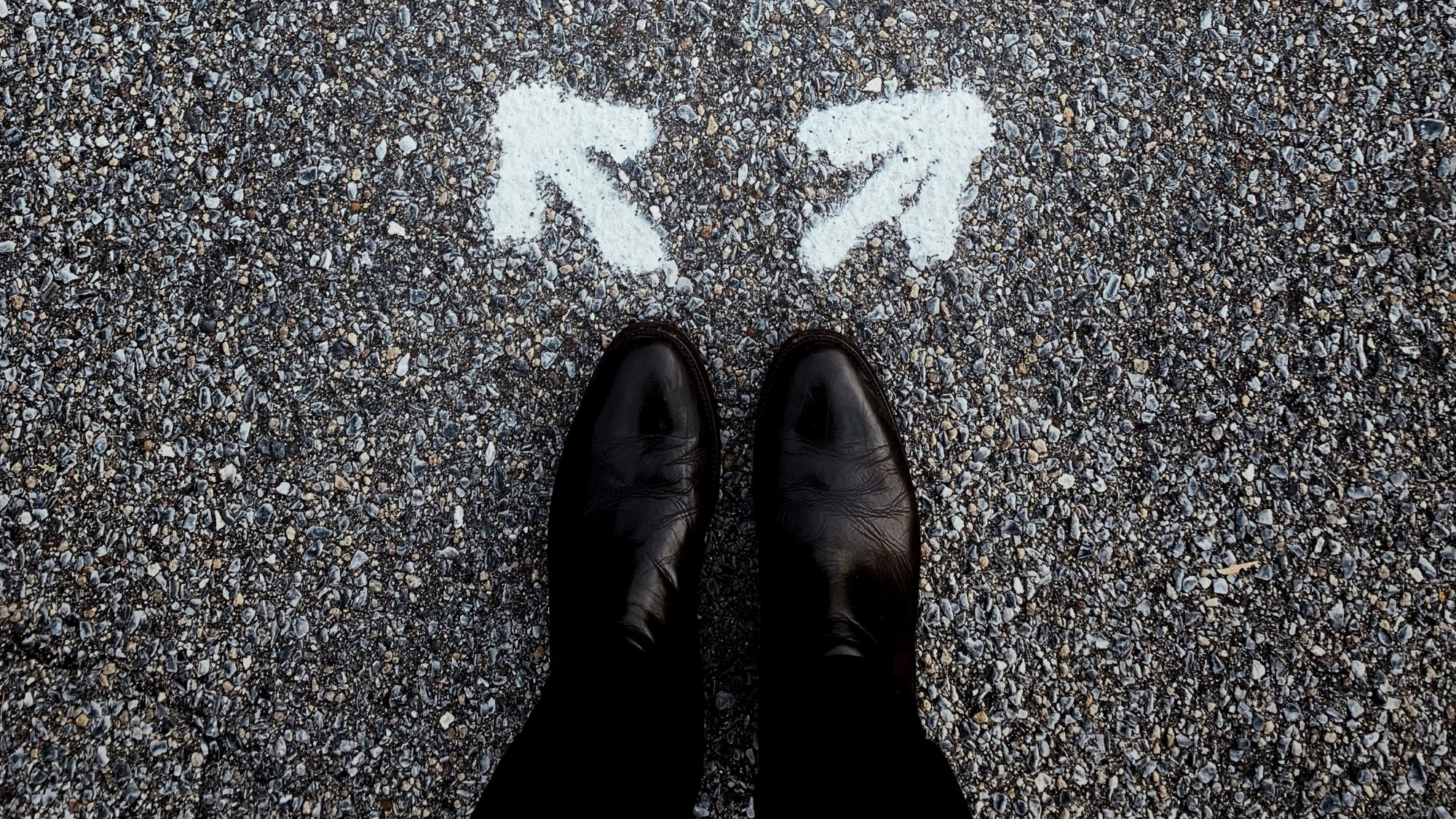 Man's shoes with two arrows pointing in opposite directions