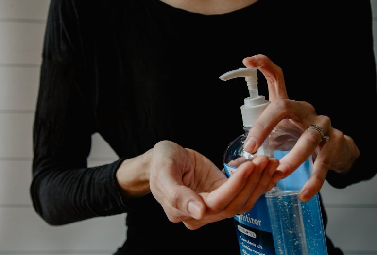 Lady cleaning her hands with sanitizer
