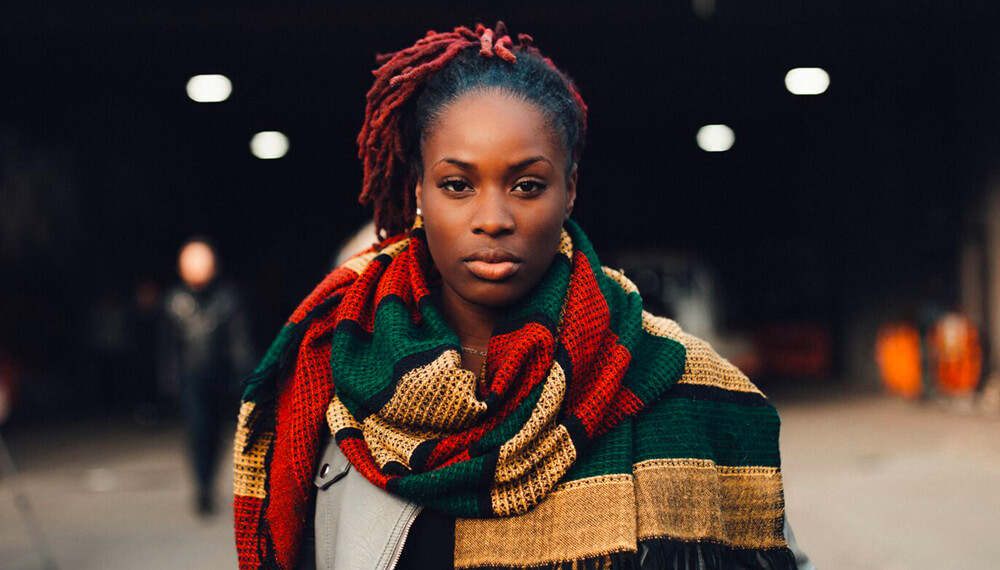 Black woman looking at camera with large scarf