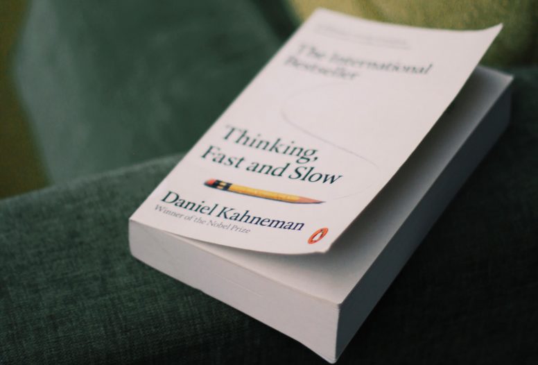 The cover to Daniel Kahneman's 'Thinking Fast and Slow' on the arm of a sofa