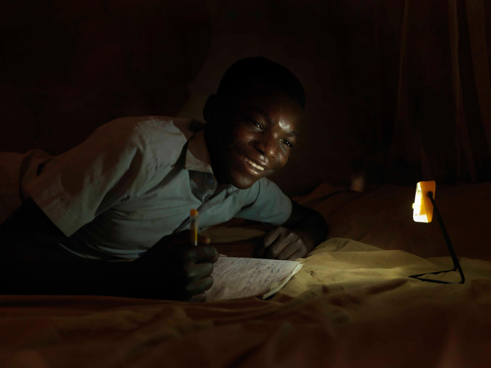 A man works a night by a SolarAid light